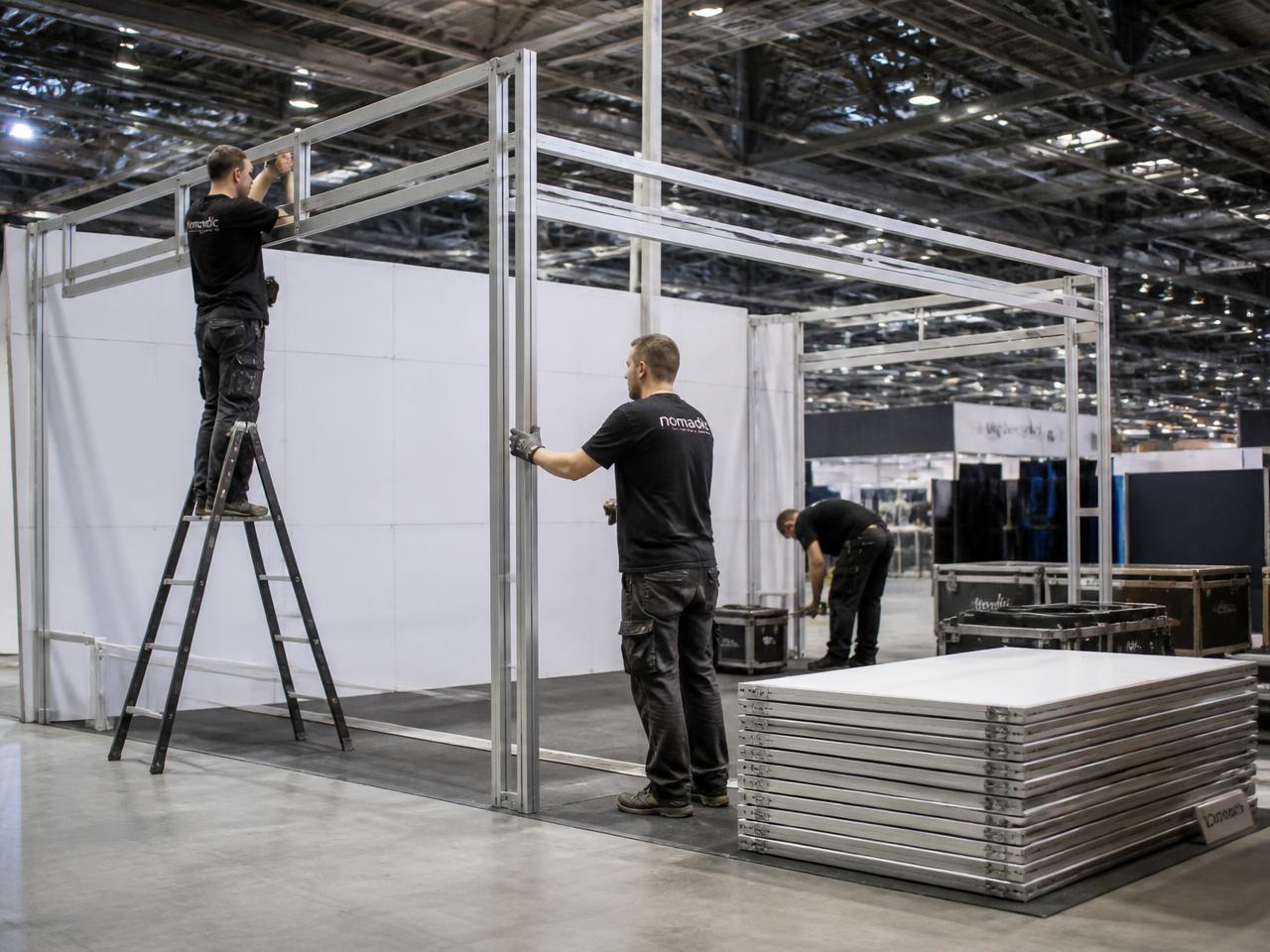 Crew assembling a modular reusable exhibition stand system